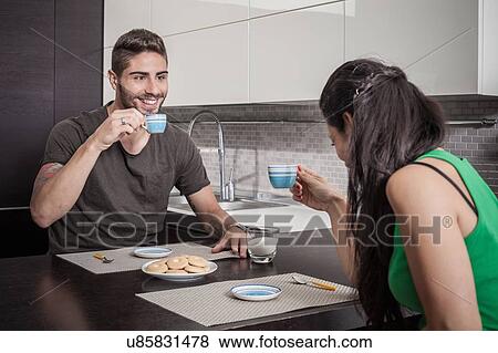 Young couple drinking coffee at breakfast bar View Large Photo Image Stock Photo - Young couple drinking coffee at breakfast bar. Fotosearch