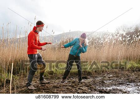 Stock Photo - Young couple hiking, fooling around, Derwent Water, Keswick, Lake District, Cumbria, United Kingdom. Fotosearch