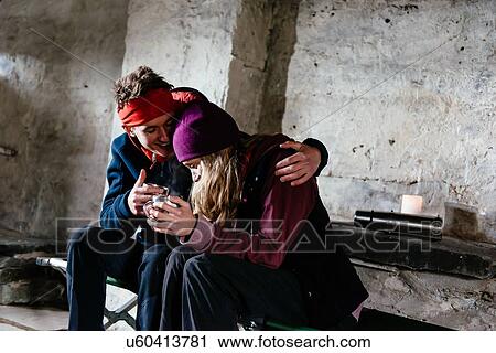 Stock Image - Young couple hiking, in shelter for rest, Honister Slate Mine, Keswick, Lake District, Cumbria, United Kingdom. Fotosearch
