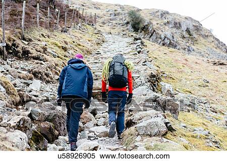 Young couple hiking, rear view, Honister Slate Mine, Keswick, Lake District, Cumbria, United Kingdom View Large Photo Image Stock Photography - Young couple hiking, rear view, Honister Slate Mine, Keswick, Lake District, Cumbria, United Kingdom. Fotosearch