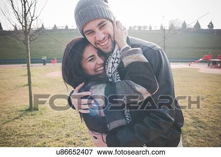 Stock Photo - Young couple hugging in park. Fotosearch