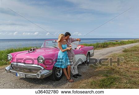 Young couple looking at map beside vintage convertible at coast, Havana, Cuba View Large Photo Image Stock Image - Young couple looking at map beside vintage convertible at coast, Havana, Cuba. Fotosearch