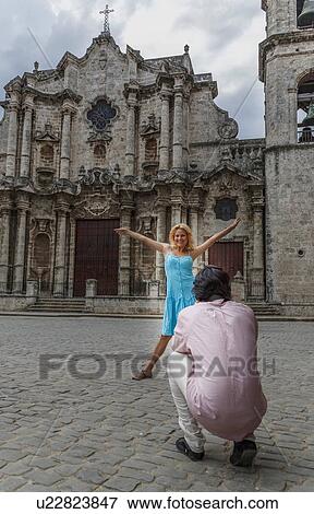 Stock Photo - Young couple taking photographs in the colonial Plaza de la Cathedral of Havana, Cuba. Fotosearch