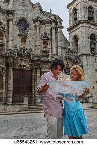Stock Image - Young couple with map in the Plaza de la Cathedral of Havana, Cuba. Fotosearch