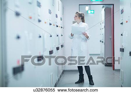 Young female scientist holding paperwork monitoring machine in technical room View Large Photo Image Stock Photography - Young female scientist holding paperwork monitoring machine in technical room. Fotosearch