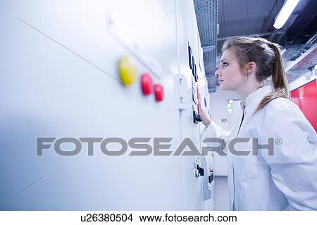Young female scientist monitoring machine control panel in technical room View Large Photo Image Picture - Young female scientist monitoring machine control panel in technical room. Fotosearch