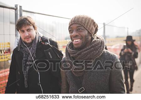 Young male friends strolling in park View Large Photo Image Stock Image - Young male friends strolling in park. Fotosearch