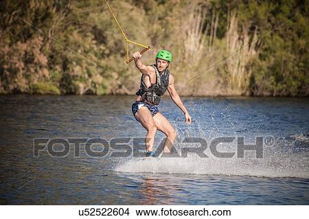 Young man in sea wakeboarding, Cagliari, Sardinia, Italy View Large Photo Image Picture - Young man in sea wakeboarding, Cagliari, Sardinia, Italy. Fotosearch