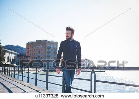 Young man strolling on lakeside, Rovato, Brescia, Italy View Large Photo Image Stock Photo - Young man strolling on lakeside, Rovato, Brescia, Italy. Fotosearch