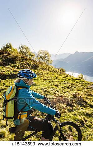 Young woman on mountain bike, looking at view, Lake Como, Italy View Large Photo Image Stock Photo - Young woman on mountain bike, looking at view, Lake Como, Italy. Fotosearch