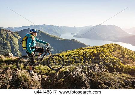 Young woman on mountain bike, looking at view, Lake Como, Italy View Large Photo Image Stock Photo - Young woman on mountain bike, looking at view, Lake Como, Italy. Fotosearch