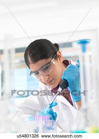 Young woman scientist pipetting sample into vial in a laboratory used for chemical and DNA testing View Large Photo Image Stock Photograph - Young woman scientist pipetting sample into vial in a laboratory used for chemical and DNA testing. Fotosearch