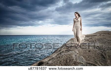 Young woman strolling along clifftop, Costa Rei, Sardinia, Italy View Large Photo Image Stock Photo - Young woman strolling along clifftop, Costa Rei, Sardinia, Italy. Fotosearch