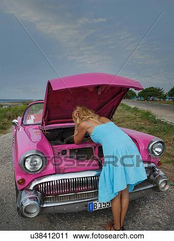 Young woman trying to fix a vintage convertible at coast, Havana, Cuba View Large Photo Image Stock Image - Young woman trying to fix a vintage convertible at coast, Havana, Cuba. Fotosearch