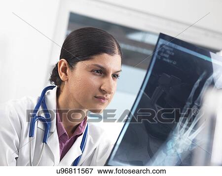 Stock Photo - Doctor studying an X-ray. Fotosearch