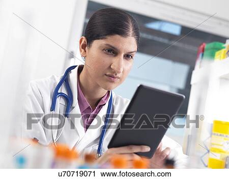 Stock Image - Doctor using a digital tablet. Fotosearch