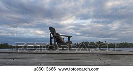 Adirondack chair on dock at lake, Lake Of The Woods, Ontario, Canada View Large Photo Image Stock Photograph - Adirondack chair on dock at lake, Lake Of The Woods, Ontario, Canada. Fotosearch