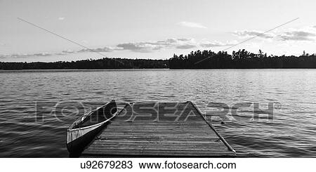 Stock Image - Canoe at the dock, Lake Of The Woods, Ontario, Canada. Fotosearch