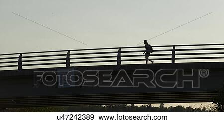 Low angle view of a woman walking on bridge, Kenora, Lake of the Woods, Ontario, Canada View Large Photo Image Stock Photo - Low angle view of a woman walking on bridge, Kenora, Lake of the Woods, Ontario, Canada. Fotosearch