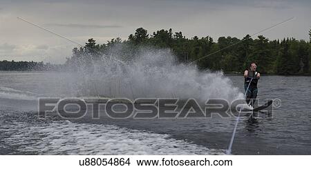 Man waterskiing in a lake, Lake Of The Woods, Ontario, Canada View Large Photo Image Picture - Man waterskiing in a lake, Lake Of The Woods, Ontario, Canada. Fotosearch