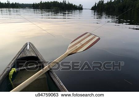 Stock Image - Oar on the side of a canoe on the lake, Lake of the Woods, Ontario, Canada. Fotosearch