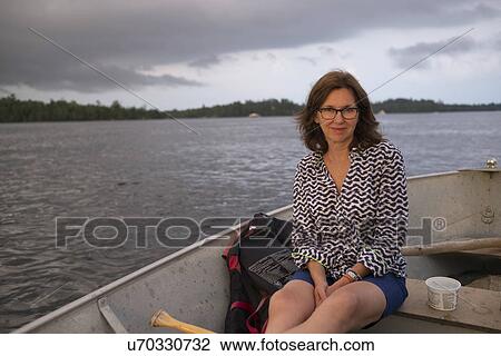 Portrait of woman sitting on a boat in a lake, Lake of the Woods, Ontario, Canada View Large Photo Image Stock Image - Portrait of woman sitting on a boat in a lake, Lake of the Woods, Ontario, Canada. Fotosearch