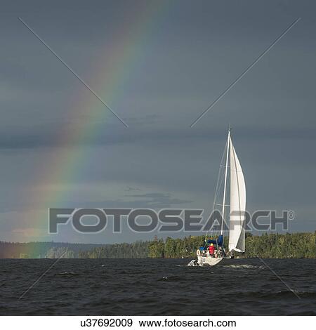 Rainbow over a lake with a sailboat, Lake Of The Woods, Ontario, Canada View Large Photo Image Stock Photo - Rainbow over a lake with a sailboat, Lake Of The Woods, Ontario, Canada. Fotosearch