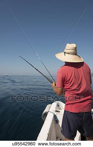 Rear view of a man fishing on boat in sea, Ixtapa, Zihuatanejo, Guerrero, Mexico View Large Photo Image Stock Image - Rear view of a man fishing on boat in sea, Ixtapa, Zihuatanejo, Guerrero, Mexico. Fotosearch