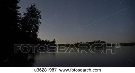 Stock Photo - Silhouette of trees at lakeside, Lake of the Woods, Ontario, Canada. Fotosearch