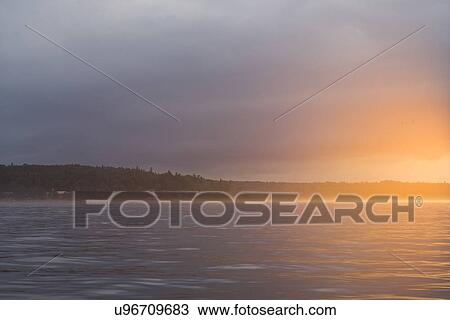 Stock Image - View of a lake at sunset, Lake Of The Woods, Ontario, Canada. Fotosearch