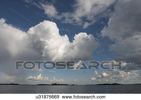 Stock Photo - View of clouds over a lake, Lake of the Woods, Ontario, Canada. Fotosearch