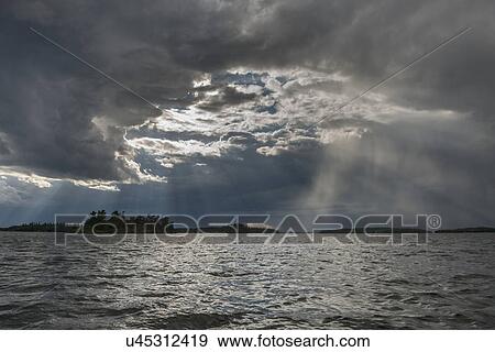 Stock Photo - View of clouds over a lake, Lake of the Woods, Ontario, Canada. Fotosearch