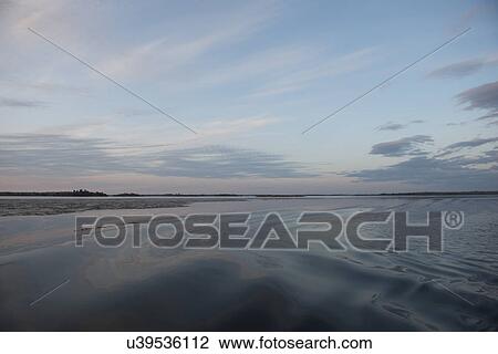 Stock Image - View of the lake surface at dusk, Lake Of The Woods, Ontario, Canada. Fotosearch