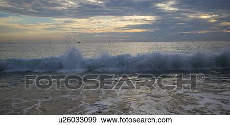 Stock Photo - View of waves on the beach at dusk, Zihuatanejo, Guerrero, Mexico. Fotosearch