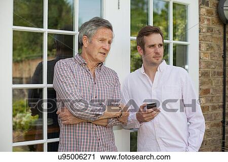 "Adult father and son, standing together, talking, outdoors" View Large Photo Image Stock Image - "Adult father and son, standing together, talking, outdoors". Fotosearch