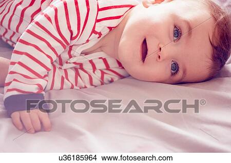Picture - Baby boy lying on bed. Fotosearch