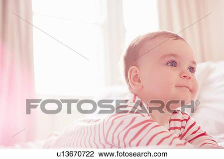 Baby boy lying on bed View Large Photo Image Stock Image - Baby boy lying on bed. Fotosearch