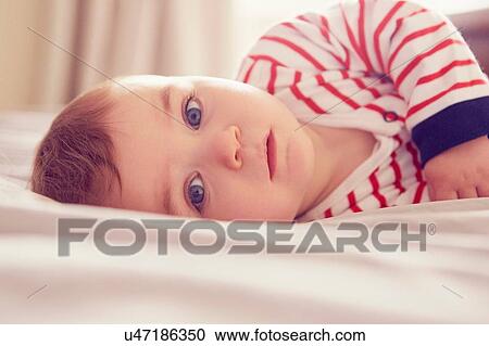 Baby boy lying on bed View Large Photo Image Stock Image - Baby boy lying on bed. Fotosearch
