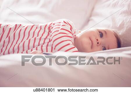 Baby boy lying on bed View Large Photo Image Stock Image - Baby boy lying on bed. Fotosearch