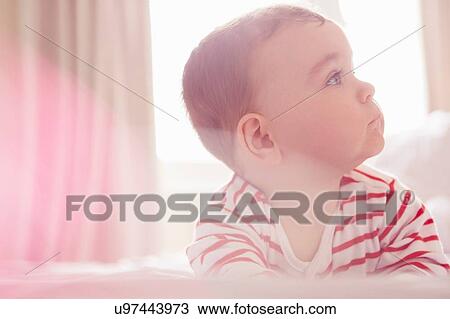 Stock Image - Baby boy lying on bed. Fotosearch