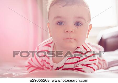 Baby boy lying on bed View Large Photo Image Stock Photo - Baby boy lying on bed. Fotosearch