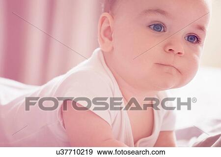Baby boy lying on bed View Large Photo Image Stock Photo - Baby boy lying on bed. Fotosearch