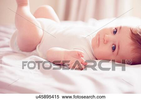 Baby boy lying on bed View Large Photo Image Stock Photography - Baby boy lying on bed. Fotosearch