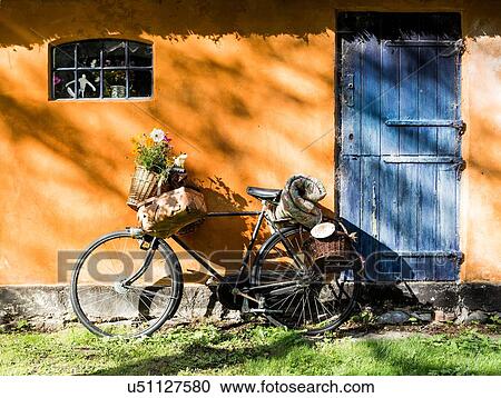 Bicycle leaning against cottaged wall with foraging baskets and wildflowers View Large Photo Image Stock Image - Bicycle leaning against cottaged wall with foraging baskets and wildflowers. Fotosearch