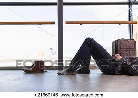 "Chest down of mid adult man lying on back on airport floor, boots removed" View Large Photo Image Stock Photograph - "Chest down of mid adult man lying on back on airport floor, boots removed". Fotosearch