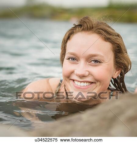 Stock Photography - "Close up portrait of young woman relaxing in Secret Lagoon hot spring (Gamla Laugin), Fludir, Iceland". Fotosearch