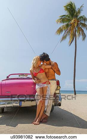 Couple beside Convertible on beach View Large Photo Image Stock Image - Couple beside Convertible on beach. Fotosearch