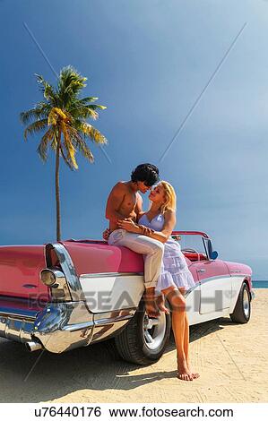 Couple beside Convertible on beach View Large Photo Image Stock Photograph - Couple beside Convertible on beach. Fotosearch