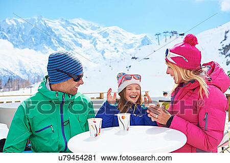 Stock Image - "Couple having coffee with daughter, Chamonix, France". Fotosearch