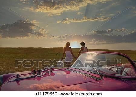 Couple with their Convertible in a field View Large Photo Image Stock Image - Couple with their Convertible in a field. Fotosearch